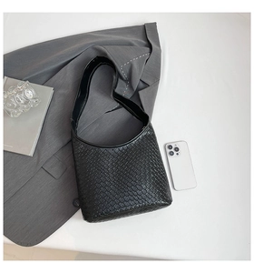 Detail of black woven shoulder bag showing intricate Intrecciato texture and matte finish