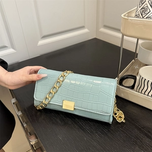 Light blue faux leather baguette bag with crocodile texture and gold chain strap