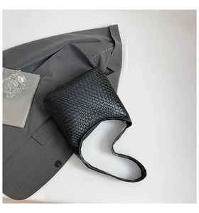 Close-up of black woven leather texture and Intrecciato pattern on the bucket bag
