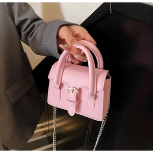 Vue détaillée d'un mini sac carré rose avec chaîne argentée et boucle décorative