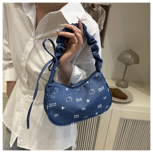 Détail du sac sous l'aisselle en denim bleu avec imprimé Hello Kitty et poignée froncée