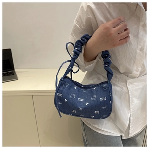 Détail du sac à bandoulière en denim avec motifs de chat blancs et anse à volants