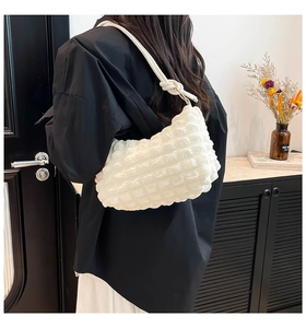 Detail of white bubble texture fabric and knot design on a stylish shoulder bag