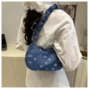 Détail du sac à épaule en jean bleu avec motif Hello Kitty et bandoulière plissée