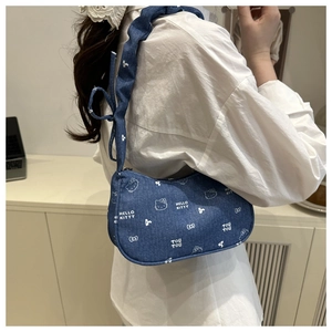 Détail du sac à épaule en jean avec motifs de chat blanc et bandoulière à nœud