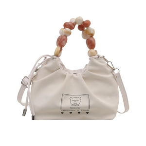 Minimalist beige ruched bucket bag with amber bead handle and brand bear print