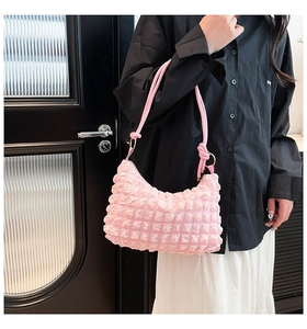 Detail view of pink pleated bubble shoulder bag with metallic ring and elastic texture