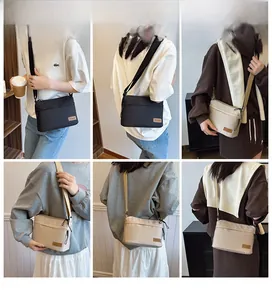 Detail view of multi-compartment crossbody bag in black and off-white colors