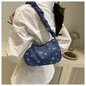 Détail du sac sous le bras en denim bleu avec imprimé mignon et bandoulière à volants
