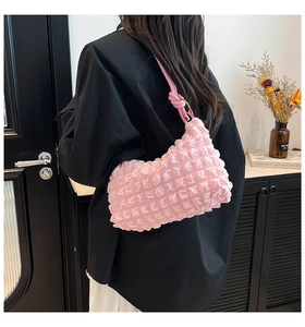 Detailed view of pink bubble pleated shoulder bag with elegant twisted strap design