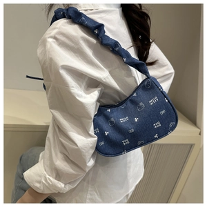 Détail d'un sac d'épaule en jean avec motifs de dessins animés et bandoulière froncée