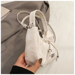 Detail of white marble textured crescent bag featuring a delicate bow knot decoration