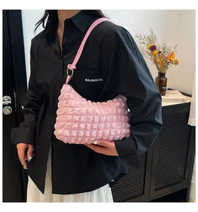 Detail of pink bubble textured shoulder bag with knotted strap and metal ring