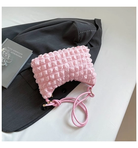 Detail of pink bubble textured shoulder bag with soft pleated fabric and slim strap