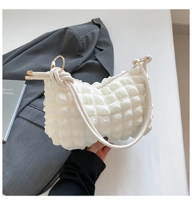 Detail of white bubble texture shoulder bag with knotted strap and gold ring connector