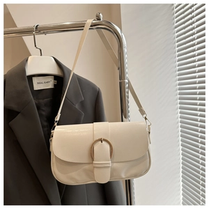 Détail du sac à bandoulière en similicuir crème avec boucle en métal doré circulaire