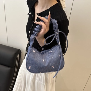 Sac à épaule en jean bleu avec motifs de nœuds roses et anse à design plissé