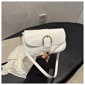Gros plan détaillé d'un sac sous le bras en cuir blanc avec une grande boucle dorée en U