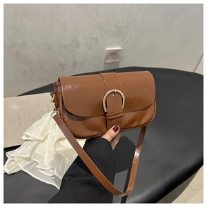 Vue détaillée d'un sac bandoulière vintage marron avec boucle dorée en fer à cheval