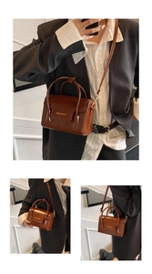 Détail du sac bandoulière en cuir marron brillant avec lettrage doré FASHION & BAGS