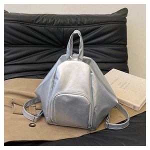 Detailed close-up of metallic silver geometric backpack with triangular 3D structure