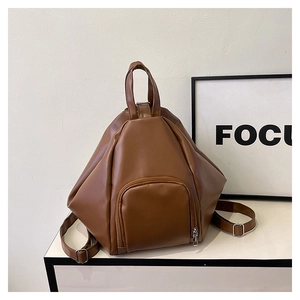 Detail view of dark brown geometric PU leather backpack with top handle and zippers
