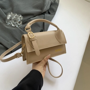 Fashionable beige leather crossbody bag with structured rectangular design and top handle