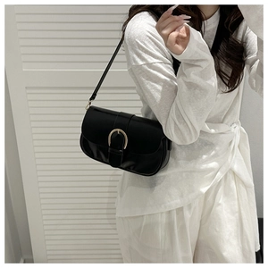 Détail du sac sous l'aisselle minimaliste en similicuir noir avec boucle en métal doré