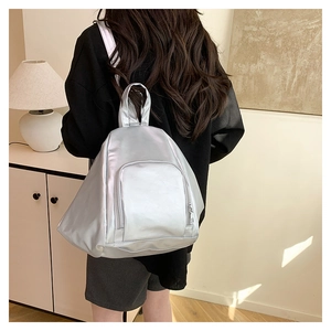 Detail of silver metallic PU leather backpack with a large main compartment and zip pocket
