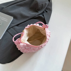 Pink bubble textured pleated shoulder bag for women with golden zipper on a gray blazer