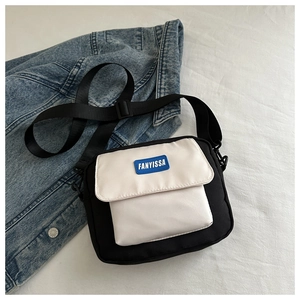 Vue détaillée du sac bandoulière bicolore noir et blanc avec sangle réglable