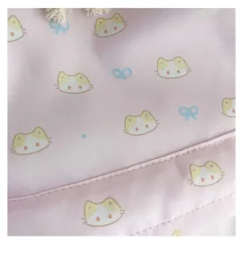 Close-up of pink casual backpack fabric featuring cute cat prints and blue bows