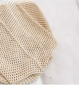 Detail of beige knit tote bag showing hollow-out crochet pattern and soft woven texture