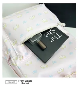Detailed view of the front zipper pocket on a pink backpack with cat patterns