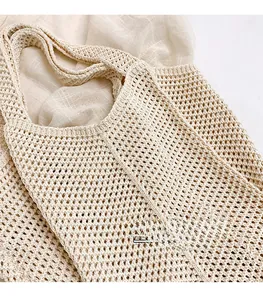 Detail of hollow knit mesh texture and beige cotton rope weaving on leisure tote bag