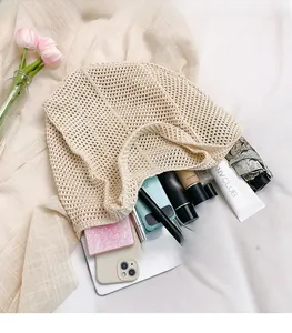Macro shot showing large capacity of beige woven crochet bag with daily essentials
