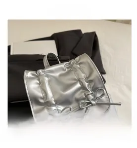 Detailansicht des silbernen Rucksacks mit Schleifen und metallischer Textur