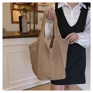 Detail of hollow-out knit tote bag featuring intricate diamond mesh texture and brown handle