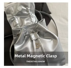 Detail des silbernen Metallic-Rucksacks mit Magnetverschluss und Kordelzug