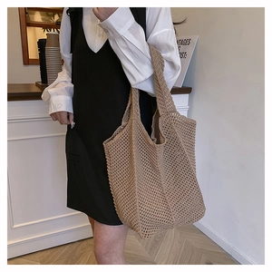 Gros plan d'un sac cabas en crochet beige montrant la texture ajourée et sa grande taille