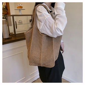 Gros plan du sac cabas tissé kaki montrant la maille ajourée et le design spacieux