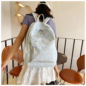 Detailed view of light blue backpack featuring cute cat patterns and bow ties for girls