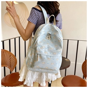 Detail of light blue backpack featuring cute cat prints and cream rope zipper pulls