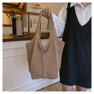 Detail of woven straw tote bag featuring a hollow mesh texture and khaki summer style