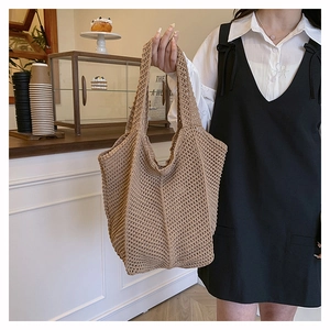 Detail of hand-woven hollow knit tote bag in khaki with mesh texture and soft structure