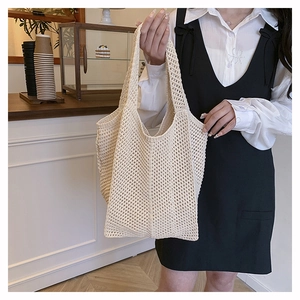 Close-up of beige knit tote bag with hollow diamond pattern and woven texture