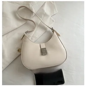 Detailed comparison of the elegant cream leather underarm bag size with a smartphone
