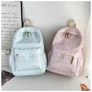 Detail of light blue and pink school backpacks with cute cat and bow patterns
