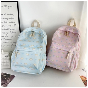 Close-up of cute light blue and pink cat print backpacks in a cozy indoor setting
