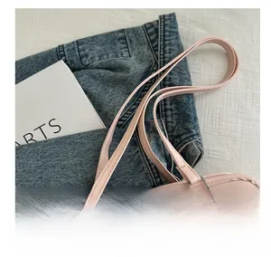Detailansicht der schmalen rosa PU-Ledergriffe und silbernen Metallbeschläge einer Tasche